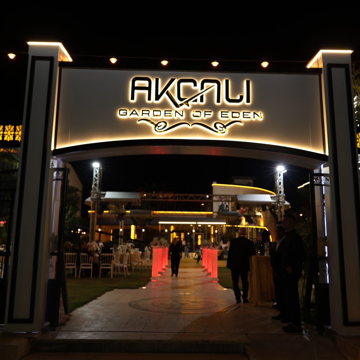 Gece ışıklandırılmış Akçalı Garden Of Eden logolu giriş kapısı
