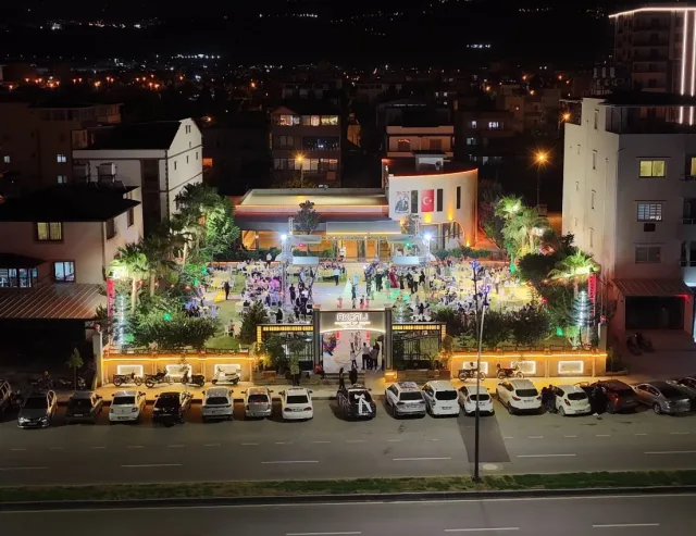 Gece caddeden görünen ışıklı mekân cephesi ve bahçe