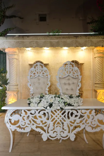 Işıklı taş kemerin önünde çiçeklerle süslenmiş gelin ve damat masası
